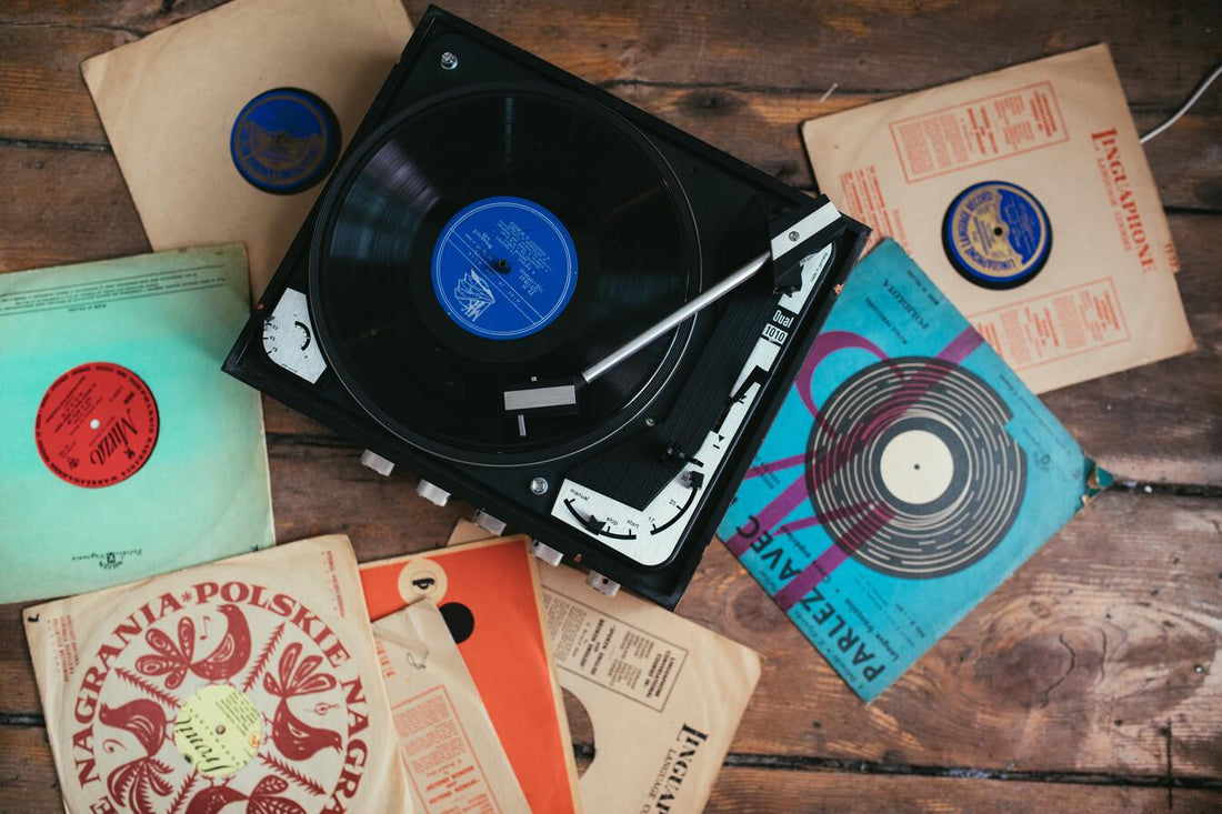 Vinyl records next to a player on wooden floor