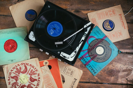 Vinyl records next to a player on wooden floor