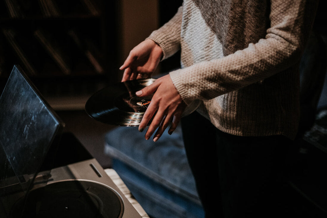 Woman holding vinyl record by the edges to prevent dusty vinyl