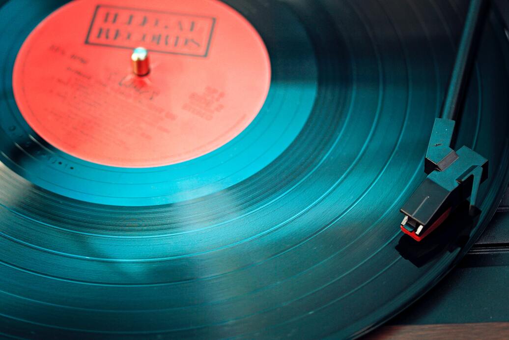 Vinyl cut black record with red label on a turntable with stylus