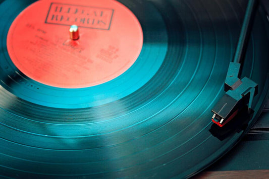 Vinyl cut black record with red label on a turntable with stylus