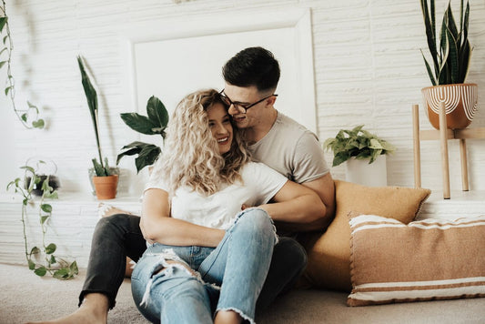 young couple seated with cushions smiling and laughing