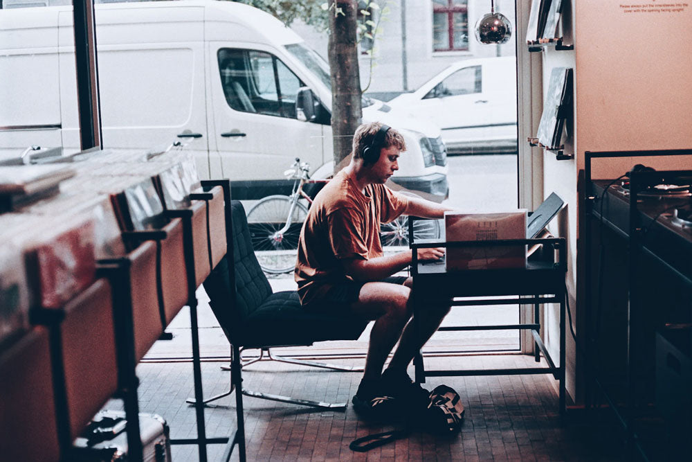 Young man at a record store listening to vinyl record