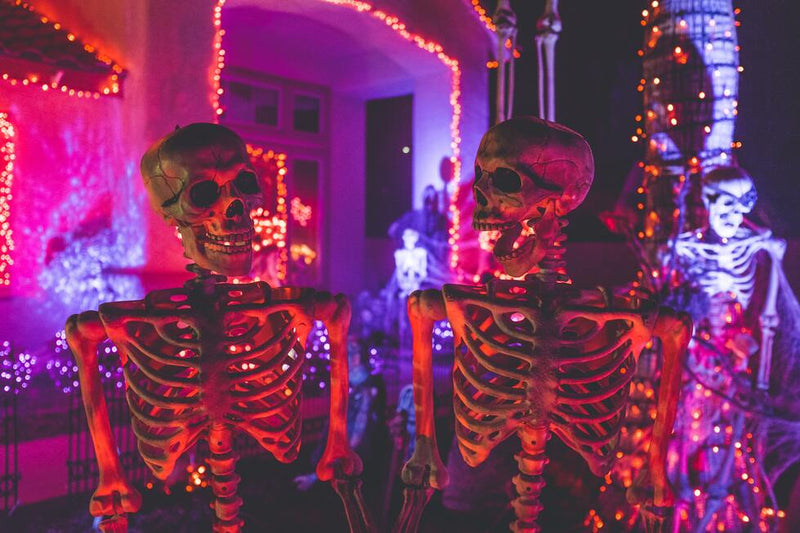 Halloween decorations with skeletons and purple/red lights.