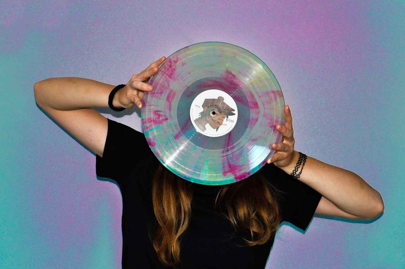 Woman holding a colorful vinyl record in front of her face