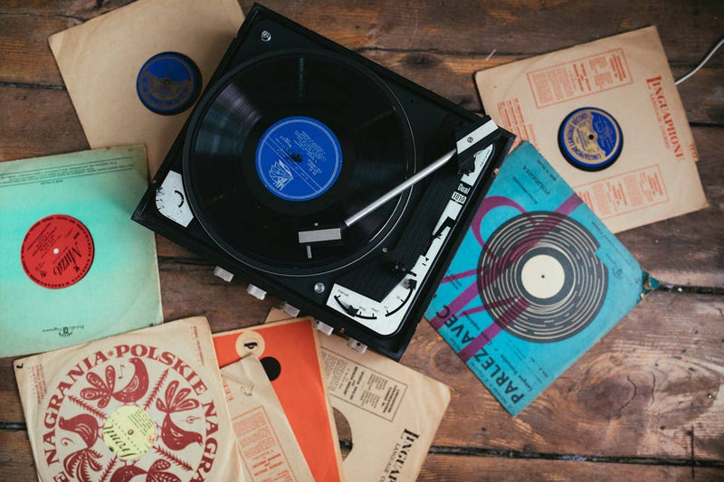 vinyl records and turntable on wooden floor