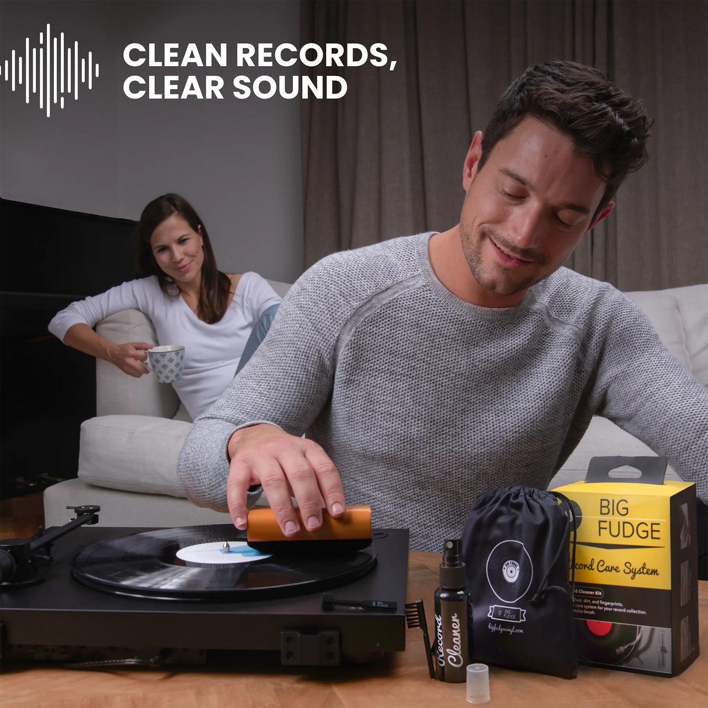 Man using a record cleaning tool with a woman in the background, text 'Clean Records, Clear Sound' above.