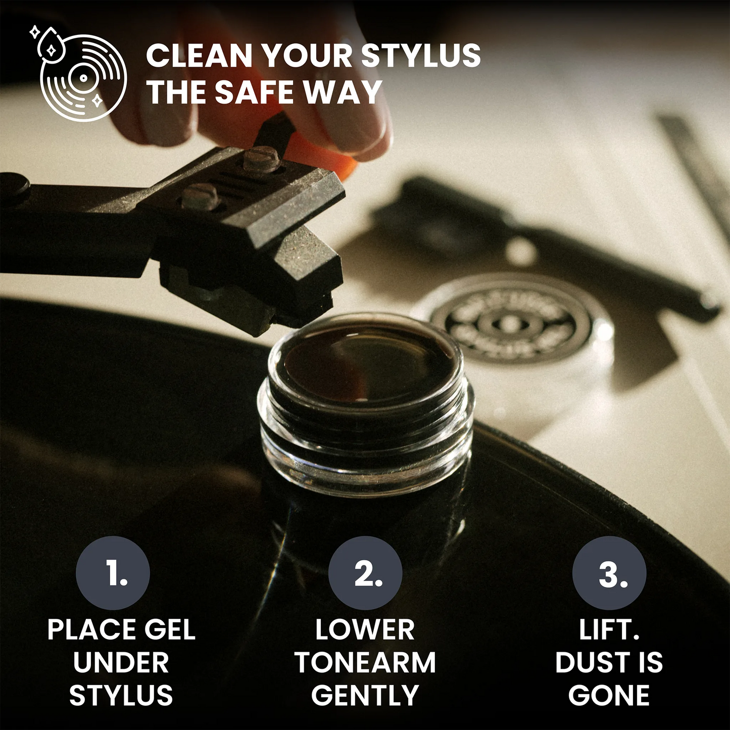 Instruction graphic showing how to clean a vinyl record stylus. A hand is shown lowering a black stylus onto a record, with three numbered steps: place gel under the stylus, lower the tonearm gently, and lift dust is gone.