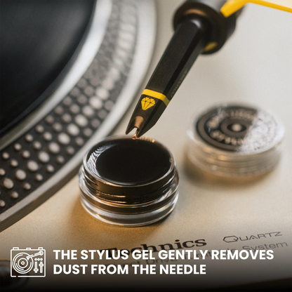 A close-up of a stylus gel pen being used to apply gel to a small clear jar, with the text 'THE STYLUS GEL GENTLY REMOVES DUST FROM THE NEEDLE' overlaid at the bottom. The stylus has a black body with a yellow accent band and a small yellow diamond-like logo, and the background shows part of a turntable with metallic silver and black tones.