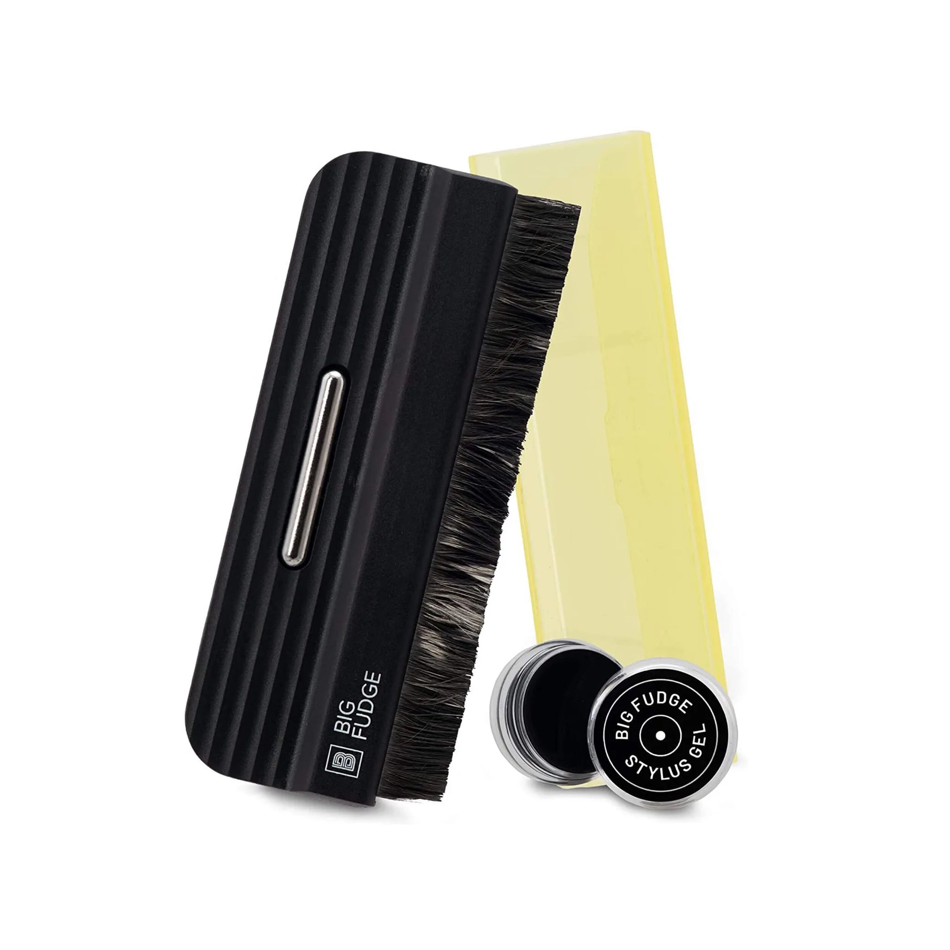 A hair styling brush set on a white background, featuring a black ribbed handle brush with dark bristles, a translucent yellow comb, and a small round black tin labeled 'BFG FUDGE STYLIST'.