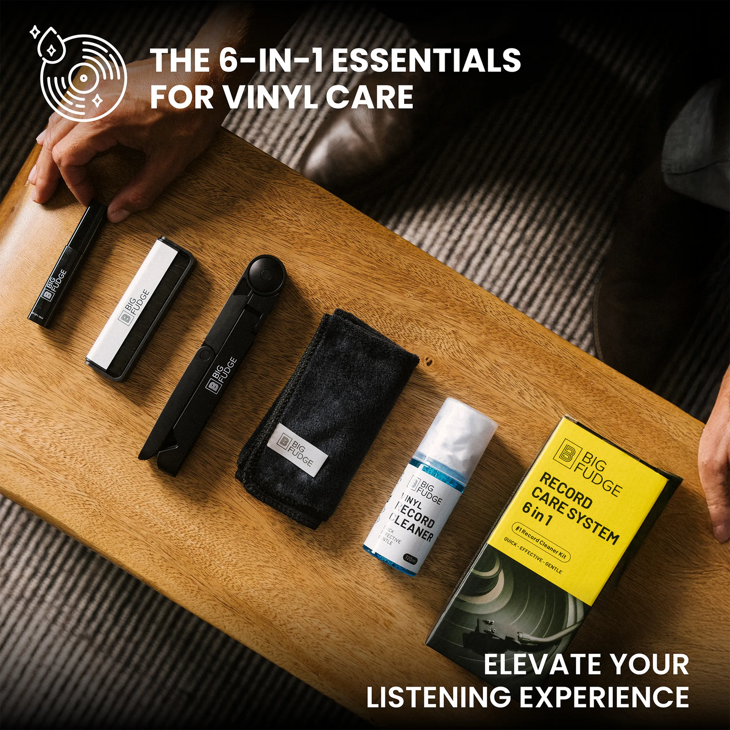 A top-down view of a vinyl record care set laid out on a wooden table, including a black cleaning tool, a white and black brush, a black microfiber cloth, a bottle of water and ethanol cleaner, and a yellow Big Ridge Record Care System box. Text overlays read 'THE 6-IN-1 ESSENTIALS FOR VINYL CARE' and 'ELEVATE YOUR LISTENING EXPERIENCE'.