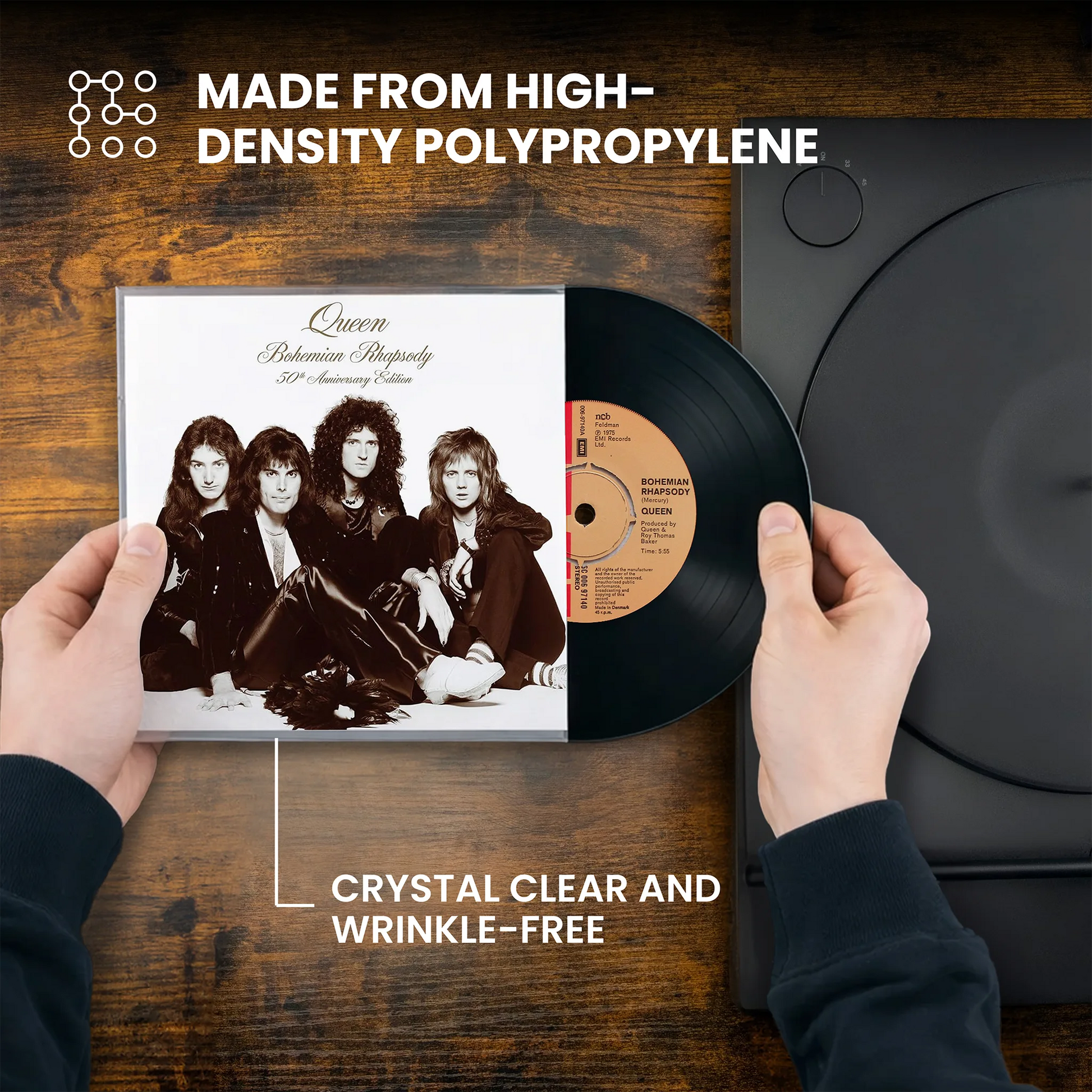 A person holds a Queen 'Bahamina Majesty 20th Anniversary Vinyl' record and its sleeve over a wooden surface next to a black turntable. White text at the top and bottom highlights high-density polypropylene and crystal clear, wrinkle-free quality. _7 inch