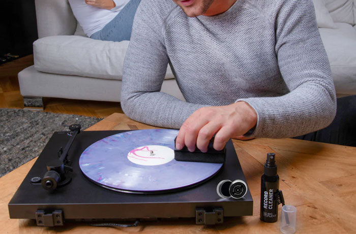 a person cleaning a vinyl record